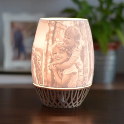 Viola personalisierte 3D-gedruckte Lampe mit Kinderporträts, die auf einem modernen Sockel im Gitterstil leuchten.